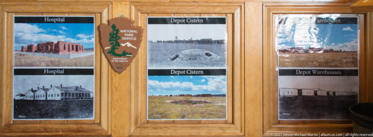 Wood-framed panel presents historic photographs and labels for Fort Union buildings, including a cistern, hospital, and warehouses.