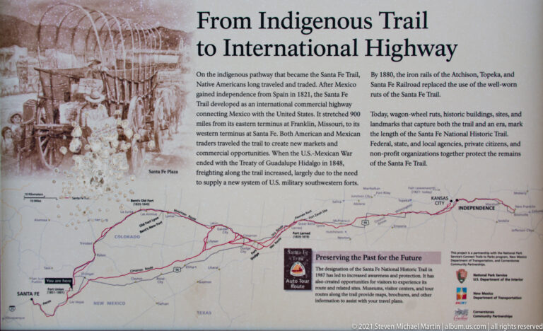 An interpretive panel titled “From Indigenous Trail to International Highway” shows a Santa Fe Trail map and text.