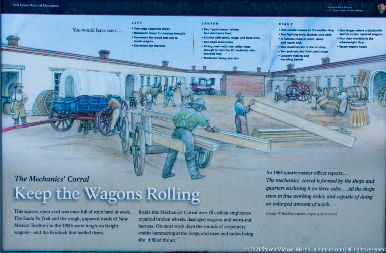 Interpretive illustration of mechanics repairing wagons in a courtyard with carts, tools, and workshop buildings.