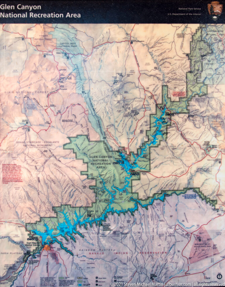 A Glen Canyon National Recreation Area map shows branching blue reservoir arms amid roads and colored boundaries.