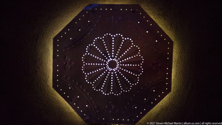 Small lights form a radial starburst inside a dark octagonal ceiling panel.