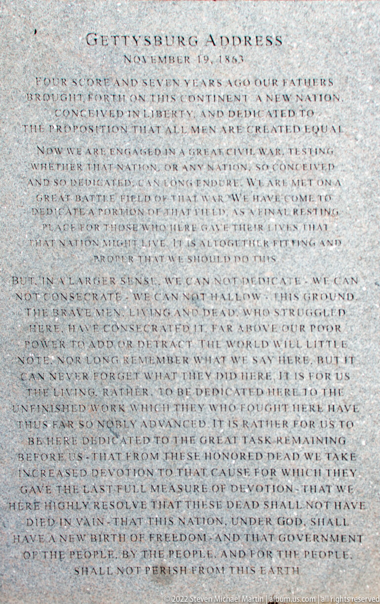 The words of the Gettysburg Address are carved in tightly spaced lines across a pale stone tablet.