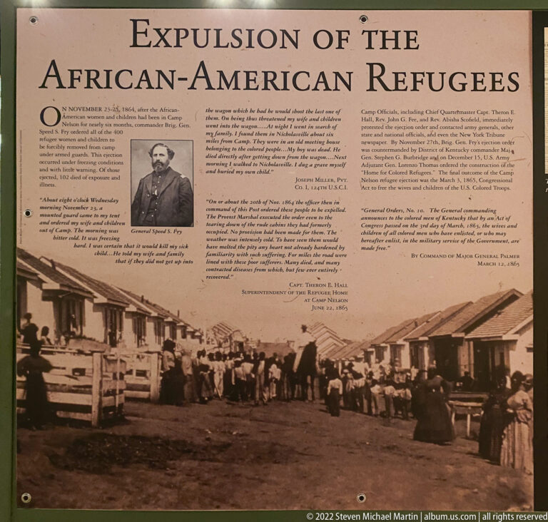An interpretive panel pairs a historic portrait and a crowded photograph of people between rows of buildings.