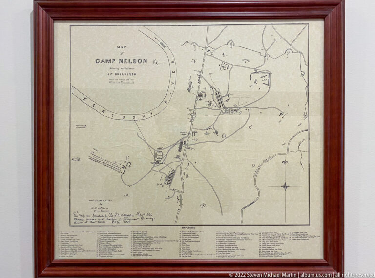 A framed map of Camp Nelson shows roads and structures, with a compass rose and legend below.