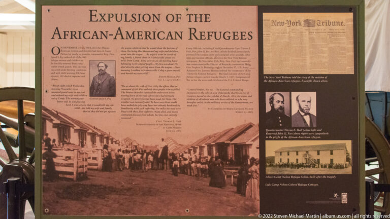 An exhibit panel about the expulsion of African American refugees combines text, portraits, a camp scene, and a newspaper clipping.