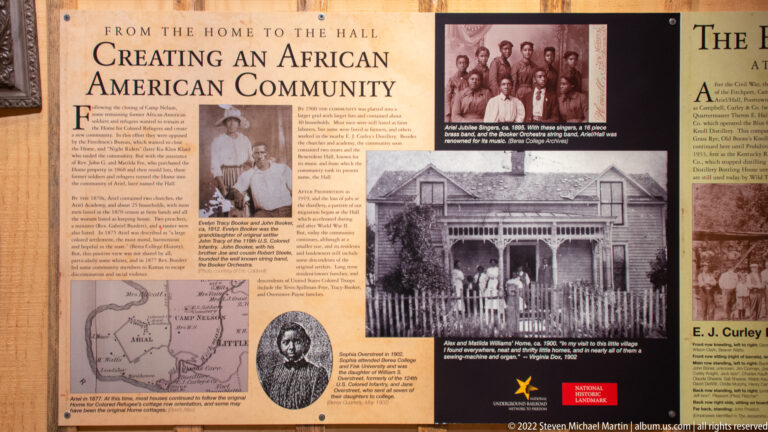An African American community exhibit panel shows portraits, a map, and historic photographs of a house and its residents.