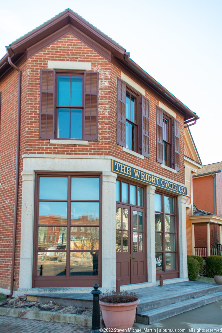 The Wright Cycle Co. sign spans the windows and doorway of a restored brick storefront.