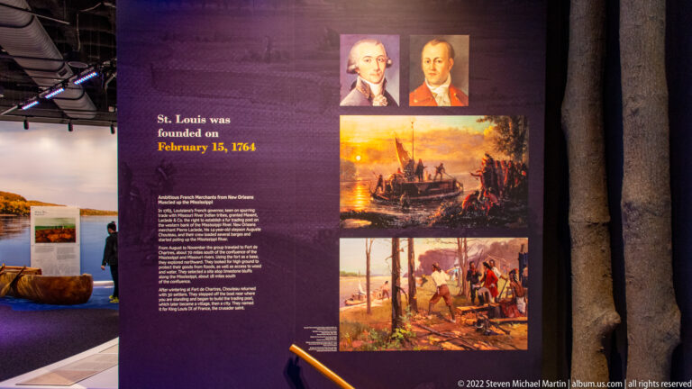 A purple exhibit panel gives St. Louis’s 1764 founding date beside portraits and historical paintings.