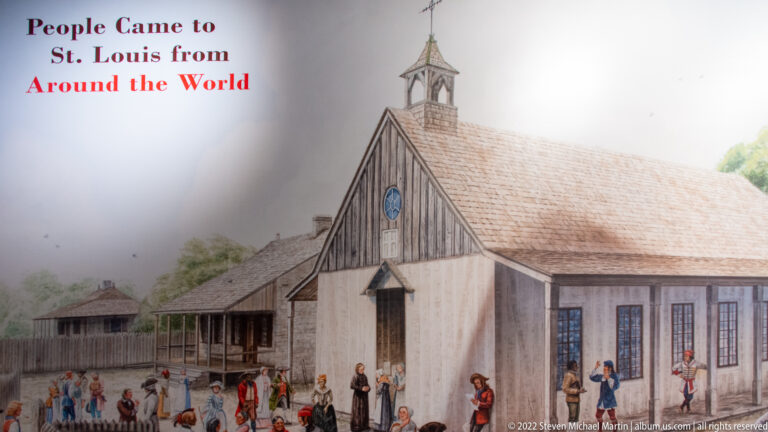 An illustrated timber building and surrounding structures stand behind groups of people in period-style clothing.