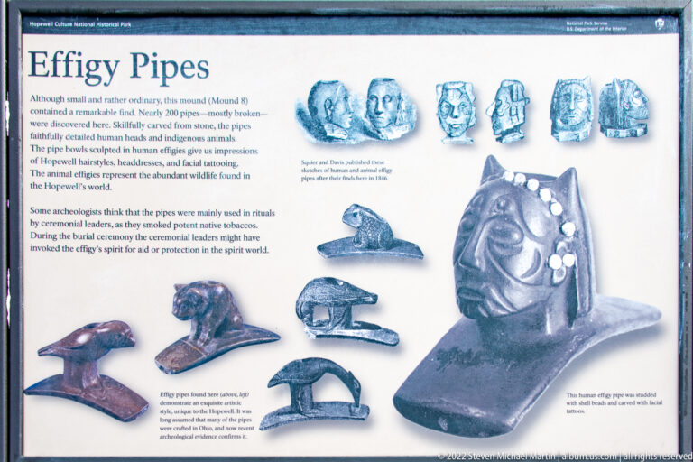 A museum panel displays carved animal-shaped pipes and sculpted face forms in several sizes.