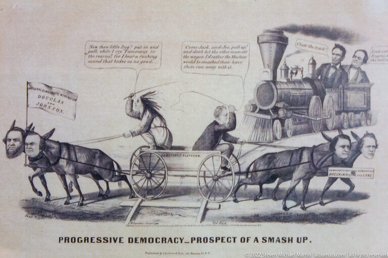 Political cartoon shows a horse-drawn wagon and steam locomotive meeting beneath the title “Progressive Democracy.”