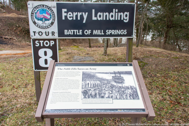 A Ferry Landing tour sign and stop-eight marker stand above a panel about the Noble Ellis river crossing.