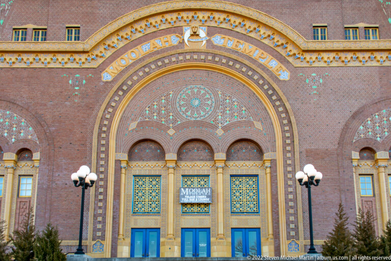 Brick entrance with mosaic arch, blue doors and the name “Moolah Shrine” above.