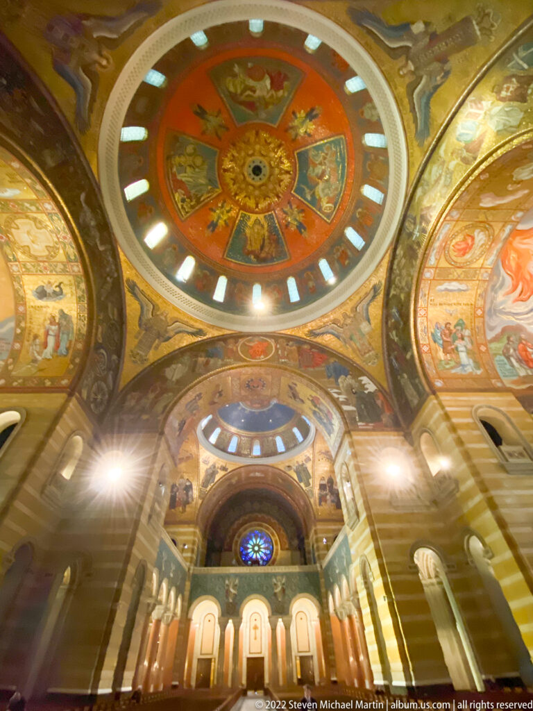 A circular mosaic dome rises above a sequence of decorated vaults and the distant sanctuary.