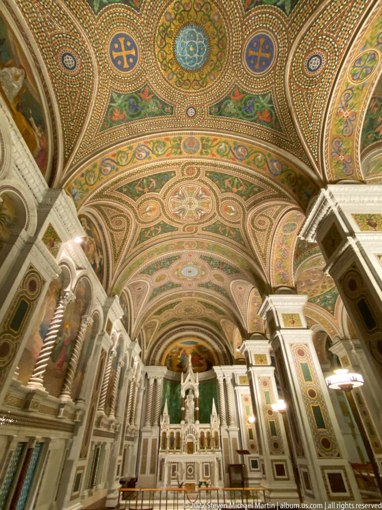 The cathedral altar and sculptural figures stand beneath patterned vaults and mosaic arches.