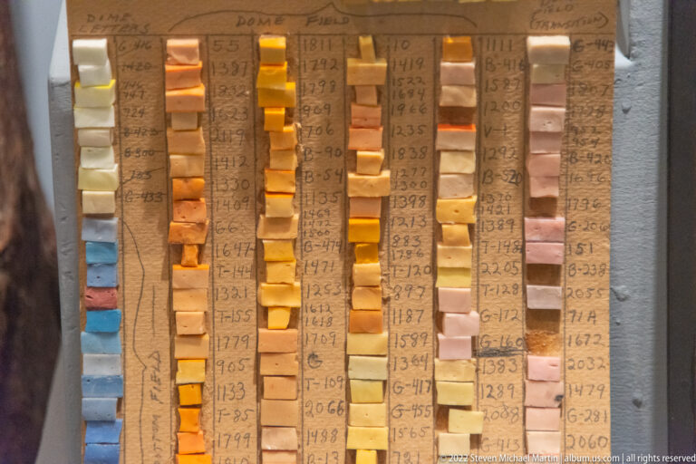 Colored mosaic samples are arranged in numbered vertical columns on an annotated board, ranging from blue and green to yellow, orange, and pink.