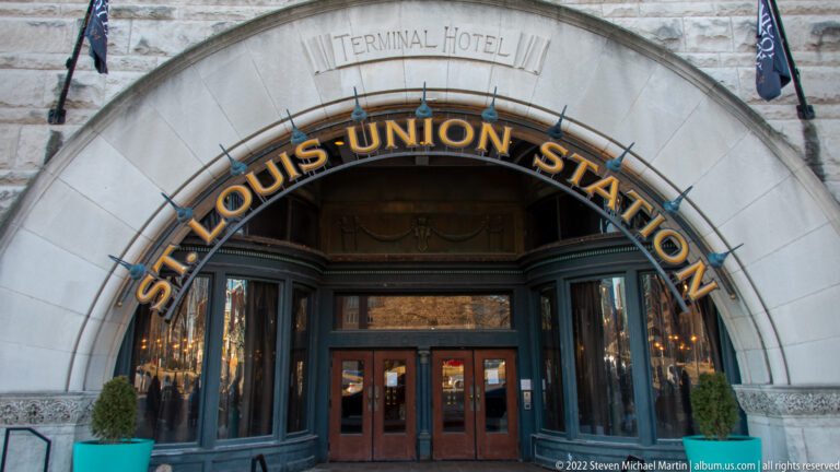 Gold Union Station lettering spans a stone arch above glass doors, with “Terminal Hotel” carved overhead.