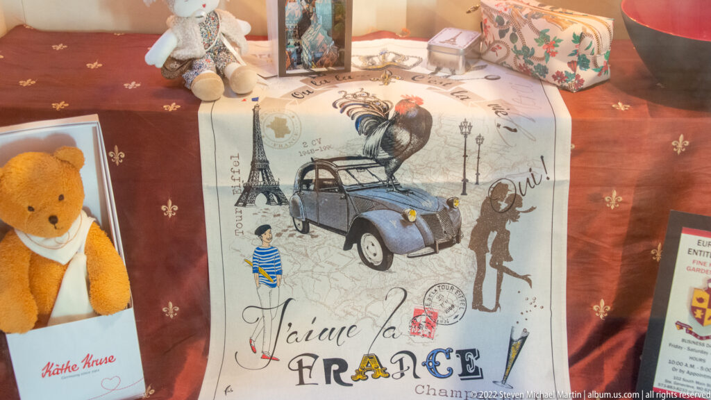 A printed textile reads “J’aime la France” beside images of the Eiffel Tower, a car, and figures.