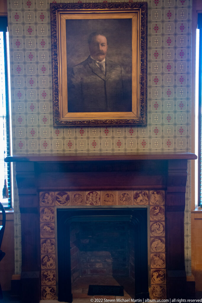 A portrait of William Howard Taft hangs above a carved fireplace mantel.
