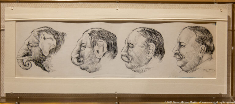 A framed drawing shows four exaggerated male profiles arranged side by side.
