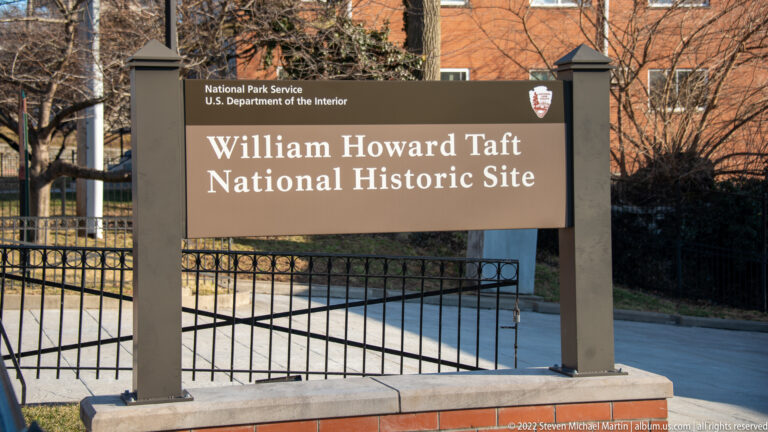 A National Park Service sign names the William Howard Taft National Historic Site beside an iron gate.