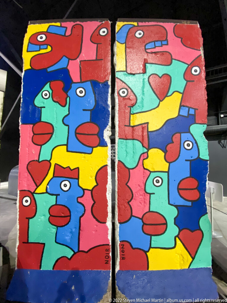 Two tall panels show repeated stylized faces in red, blue, green, and yellow, with a heart motif.