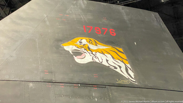 A gray aircraft panel marked 17976 carries a painted snarling tiger head.