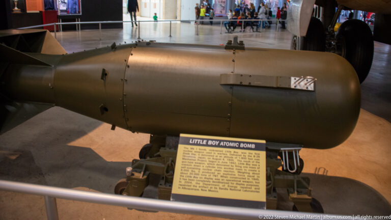 The Little Boy atomic bomb rests behind a barrier with its name and information panel in front.