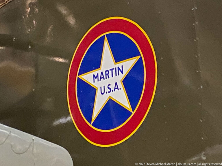 A circular red, white, and blue emblem reads “MARTIN U.S.A.” on an olive aircraft.