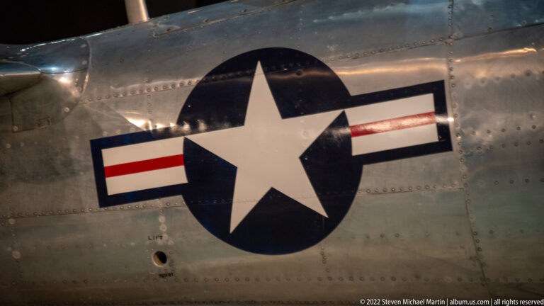 A white star in a blue roundel with red and white bars is painted on riveted metal aircraft skin.