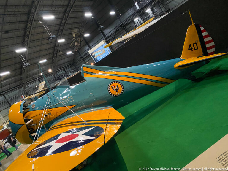 A green-and-yellow biplane marked 40 has a U.S. roundel on its yellow wing.