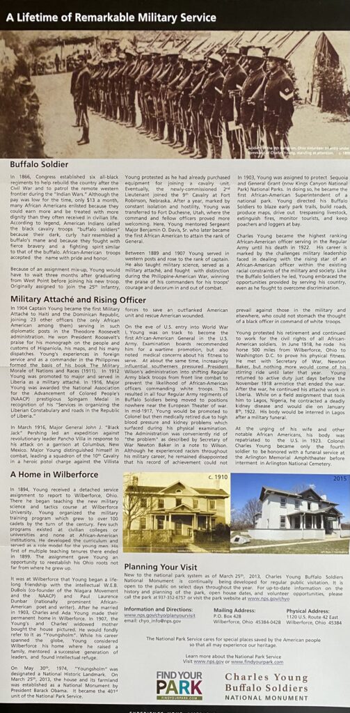 A military history panel pairs a sepia wagon photograph with text sections and color images of a house and monument grounds.