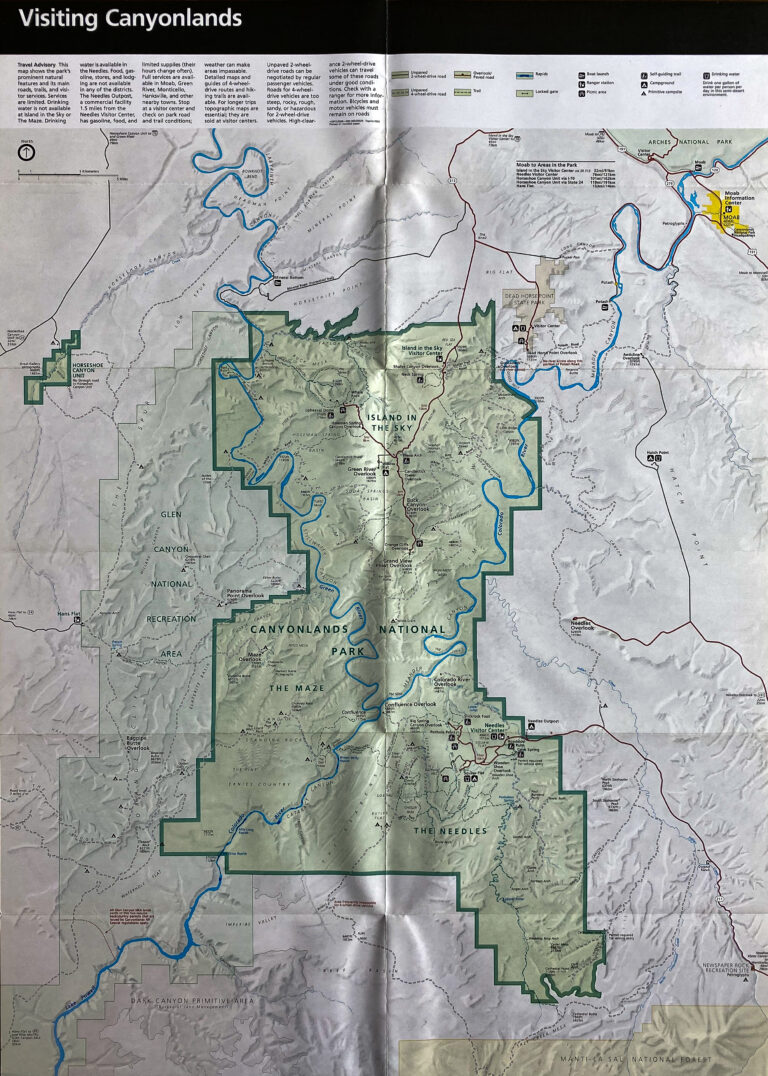 A folded park map marks a broad green boundary, blue waterways, roads, and surrounding terrain.