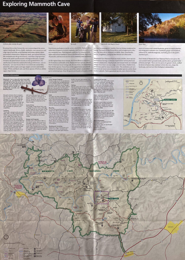 A Mammoth Cave guide shows a large labeled park map beneath visitor information and small photographs.