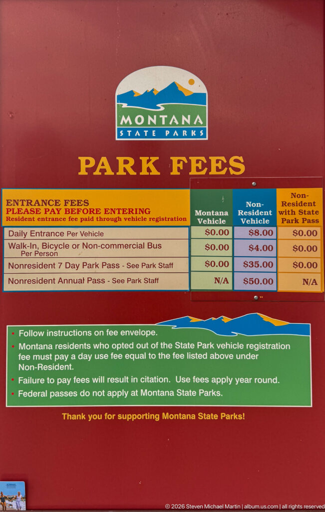 Red Montana State Parks fee sign with entrance charges and visitor payment instructions.