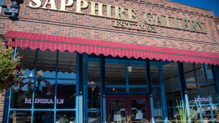 Sapphire Gallery storefront with gold wall lettering, red awning, blue window frames, and MINERALS lettering on the glass.