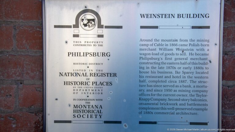 Historical plaque titled WEINSTEIN BUILDING mounted on brick, with Philipsburg Historic District and National Register information.