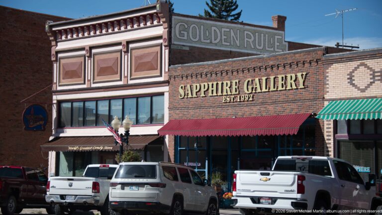 Ornate Walker Commercial Company façade beside the former C.T. Huffman Grocery building marked Sapphire Gallery, with awnings and parked vehicles.