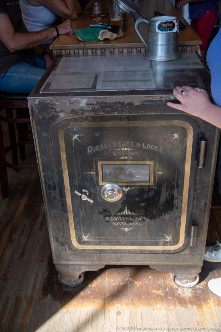 Large antique Diebold Safe & Lock Co. safe with combination dial, handle, painted door, and heavy hinges on a wood floor.