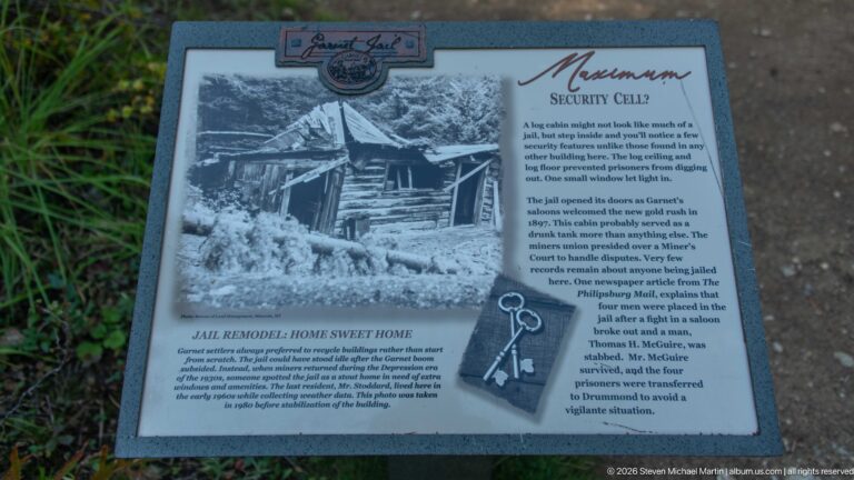 Interpretive panel titled Maximum Security Cell with a historic log jail photograph, text, and illustration of keys.