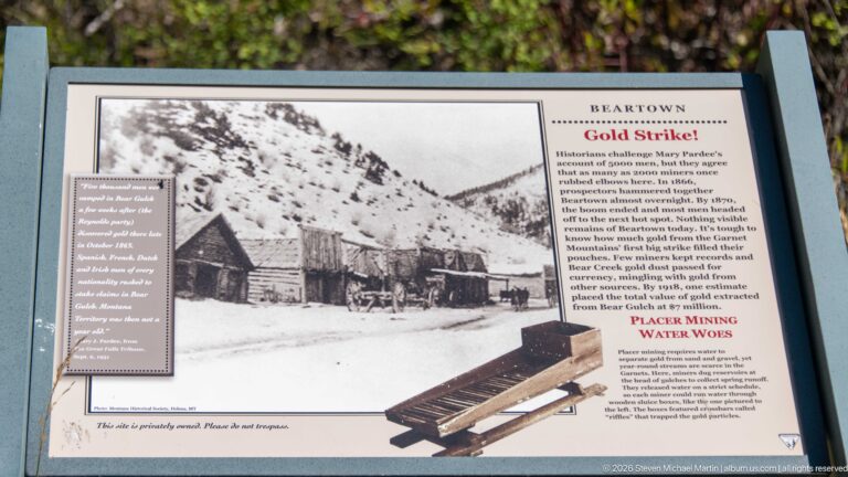 Outdoor Beartown interpretive panel titled Gold Strike!, with a historic mining-camp photograph and text about placer mining.